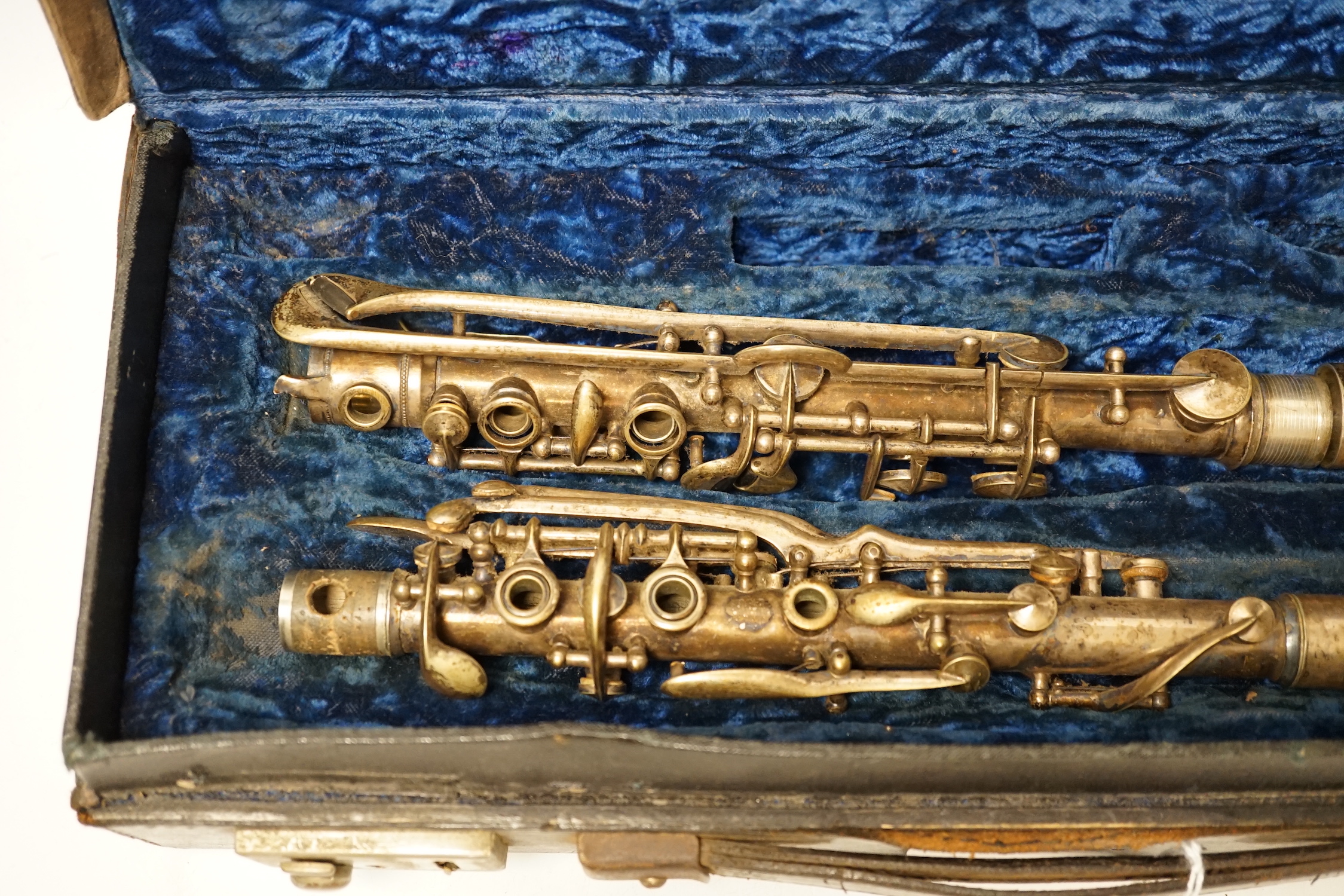 An early 20th century cased Boosey & Hawkes clarinet with plated metal body, bell engraved with ‘Lucian Bassi, British Agents Heywood & Sons, Blackpool’